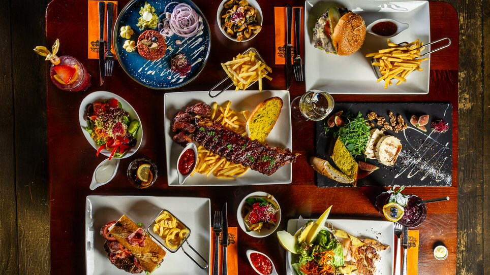 A diverse menu on a table featuring various dishes. | © Studio Creativ -Paul Stajan