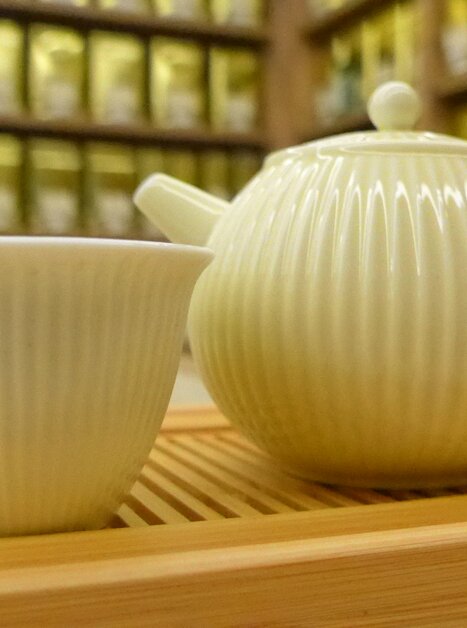 Una teiera e una tazza chiare su un vassoio di legno. | © Martin Laschat