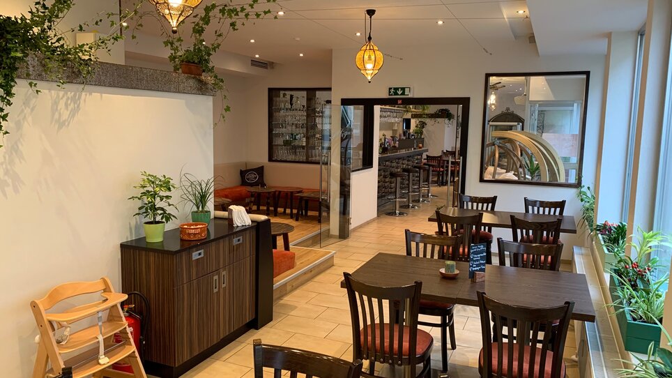 Cozy restaurant atmosphere with tables and plants. | © R&D Gastro OG