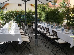 A decorated garden terrace with tables and chairs, ready for dining. | © Das Lorenz