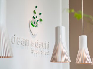Logo von dean&david mit hängenden Lampen in einem modernen Ambiente. | © dean&david