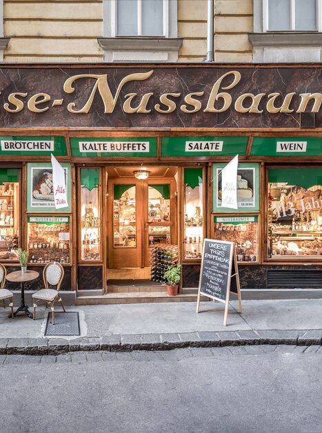 Negozio di gastronomia tradizionale Käse-Nussbaumer a Graz con posti a sedere all'aperto. | © Delikatessen Nussbaumer
