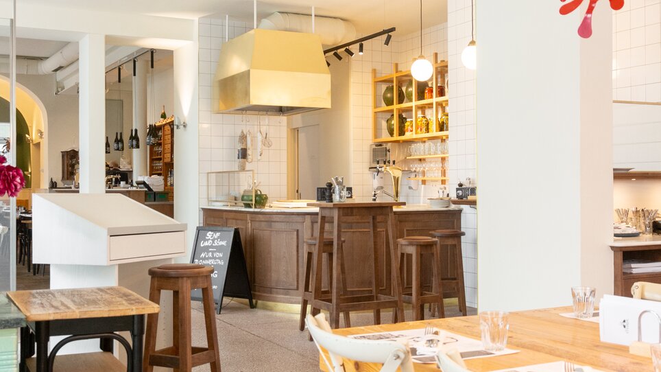 Interior view of Restaurant Der Steirer in Graz featuring wooden chairs and a bar. | © Florian Weitzer Hotels & Restaurants