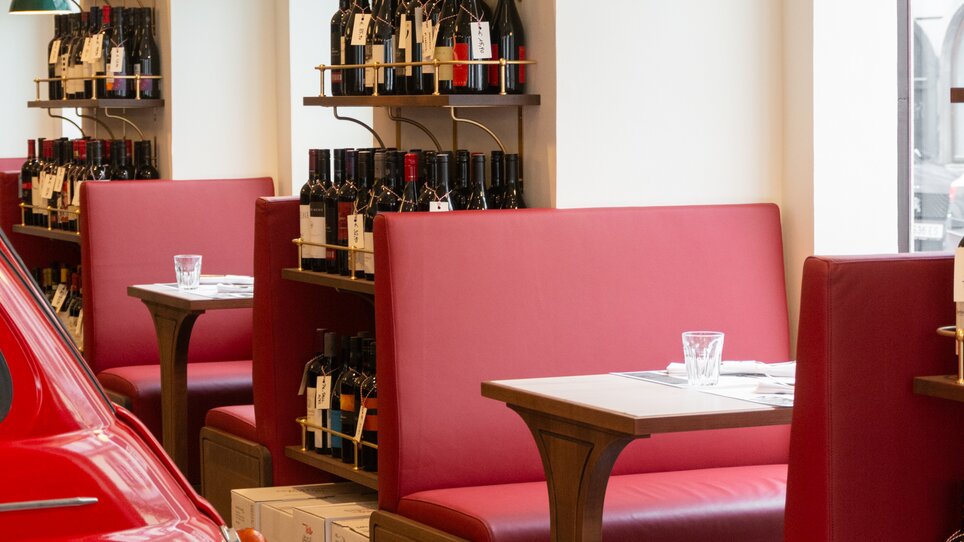 Cozy restaurant with red benches and wine shelves. | © Florian Weitzer Hotels & Restaurants