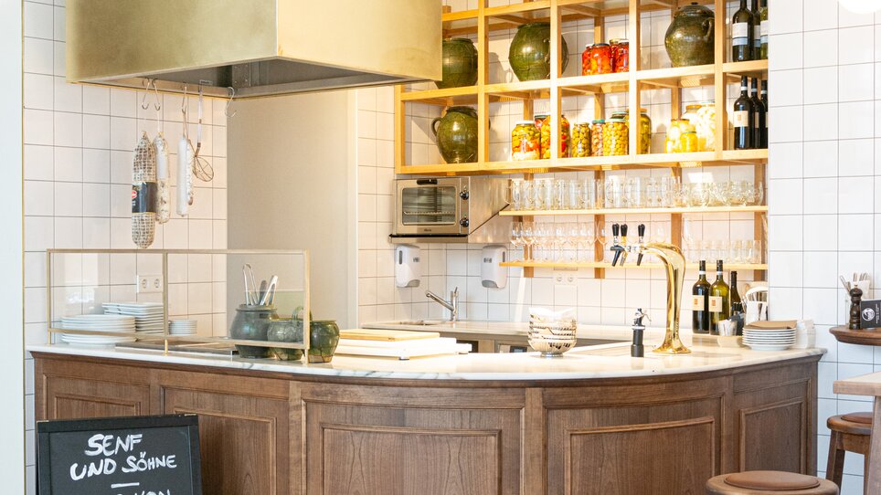 Modern bar featuring wooden details and green decor items. | © Florian Weitzer Hotels & Restaurants