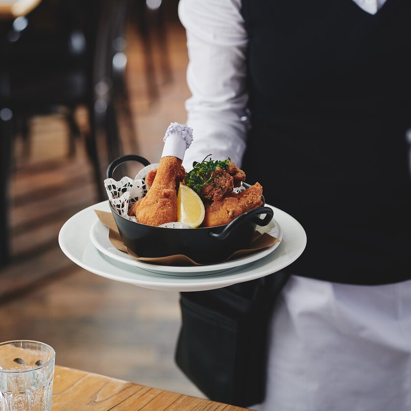 Ein Kellner serviert ein Gericht in einem Restaurant. | © Florian Weitzer Hotels & Restaurants