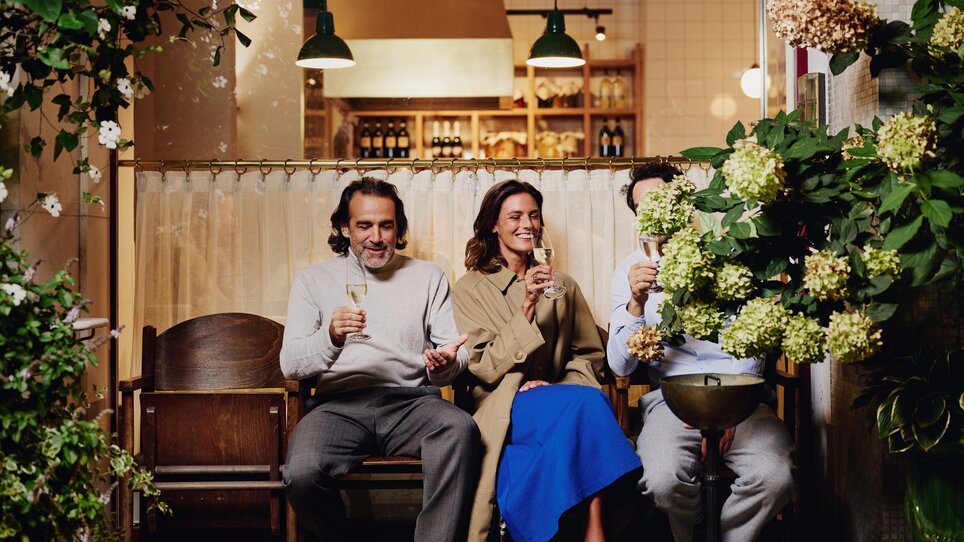 Three people are enjoying drinks in a cosy atmosphere in front of the restaurant ‘Der Steirer’. | © Florian Weitzer Hotels & Restaurants
