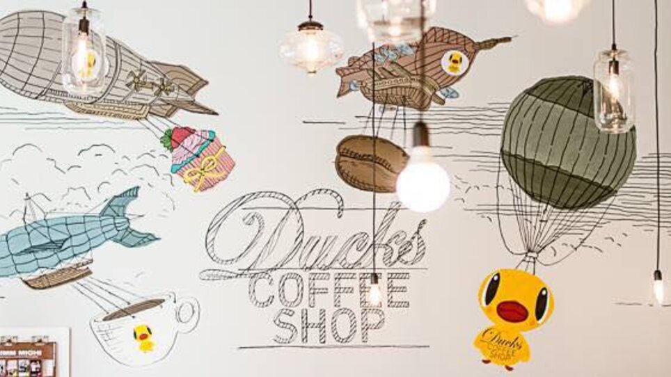 Cozy wall mural in Ducks Coffee Shop featuring balloons and a duck theme. | © Ducks Coffee