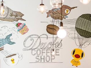 Cozy wall mural in Ducks Coffee Shop featuring balloons and a duck theme. | © Ducks Coffee