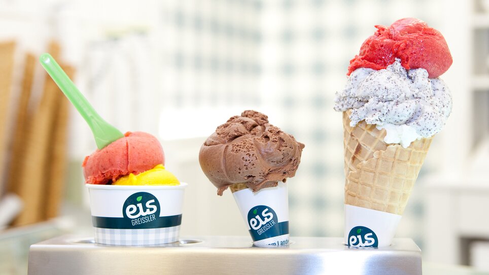 A cup of raspberry ice cream, a cone of chocolate ice cream and a cone of raspberry and poppy seed ice cream at the Eis-Greisslerei in Graz. | © Eis Greissler