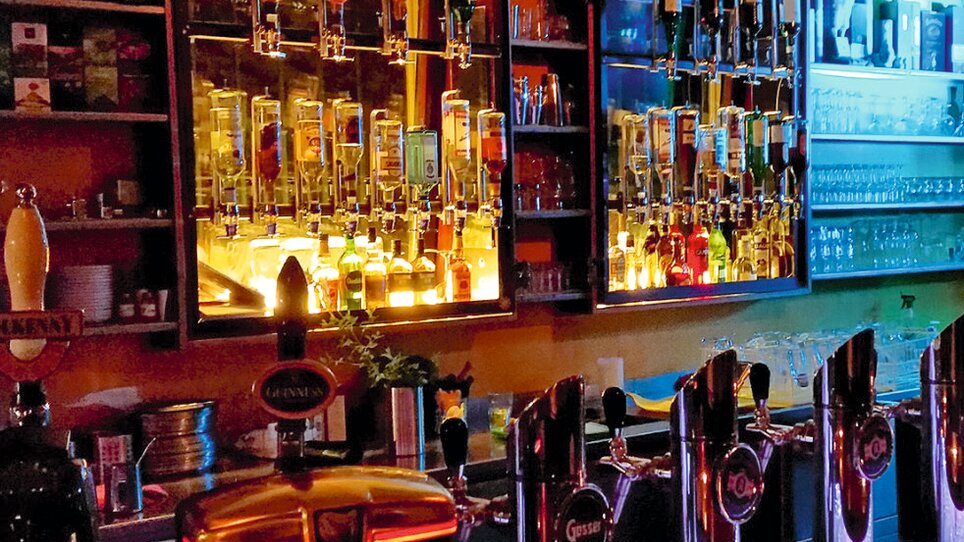 Bar mit einer Vielzahl von Spirituosen und Getränken in warmem Licht. | © Eschenlaube