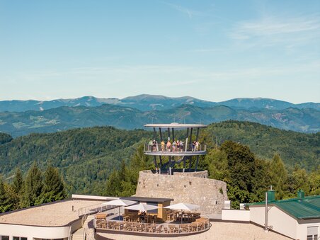 An observation tower with a restaurant in Graz and mountain scenery. | © Graz Tourismus - Mias Photoart