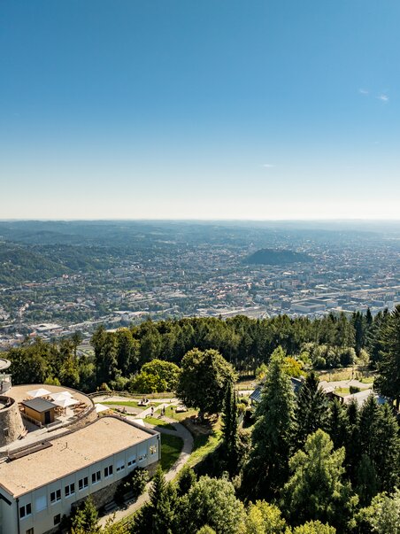 View over Graz from Fürstenstand with clear skies and green forests. | © Graz Tourismus - Mias Photoart