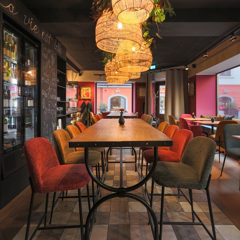 Modernes Bistro mit gemütlicher Einrichtung, stilvollen Lampen und rotem Farbkonzept. | © Makinson Media