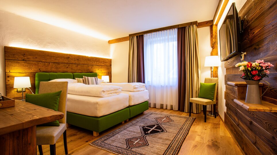 Stylish hotel room featuring two beds and bright design. | © Gasthof Lend-Platzl