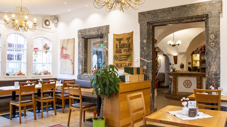 Cozy restaurant interior with tables and plants. | © Gasthof Lend-Platzl