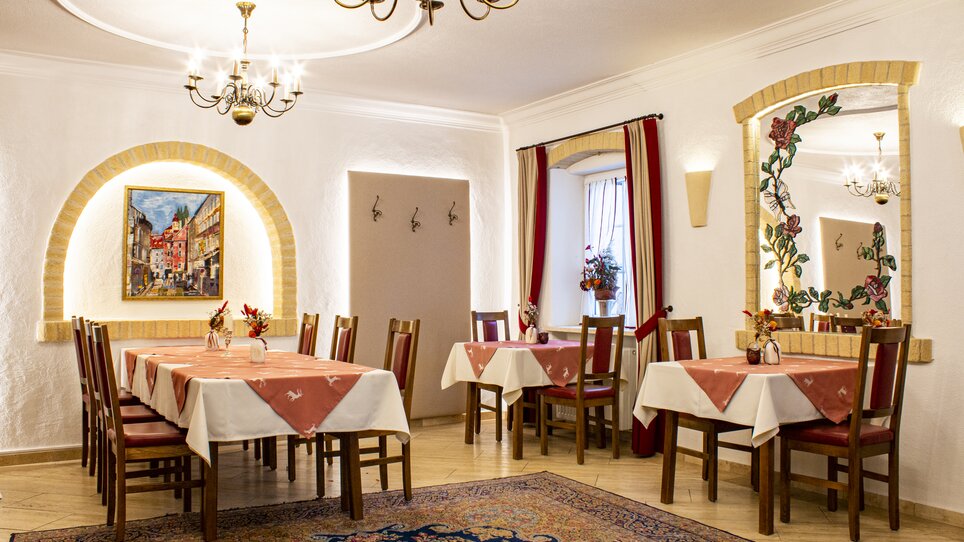 Cozy restaurant with tables, wooden chairs, and decorative elements. | © Gasthof Lend-Platzl