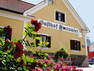 Facade of Gasthof Sternwirt with flowers in the foreground. | © Sternwirt