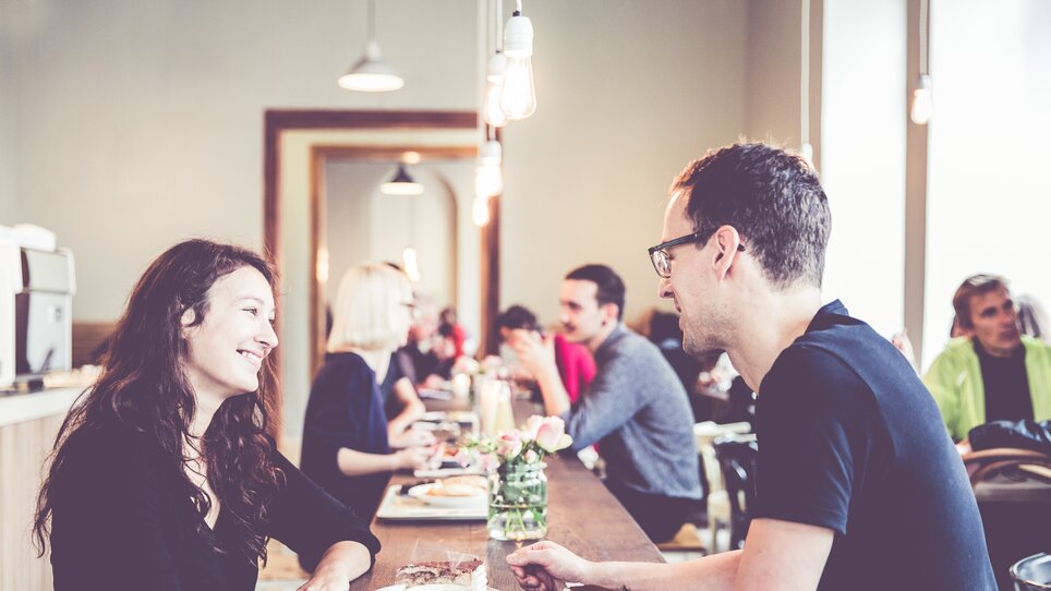 Ein Paar genießt Getränke und Kuchen in einem Café. | © Lupi Spuma