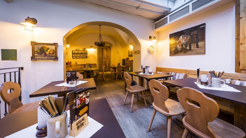 A cozy restaurant interior with wooden chairs and tables. | © Glöckl Bräu