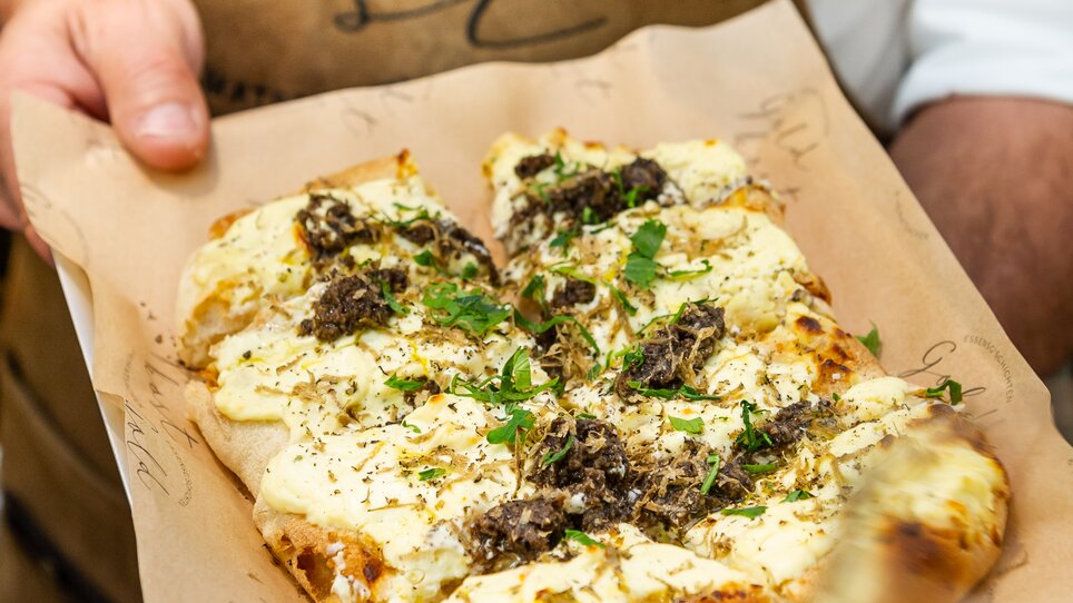 Un piatto appena preparato con erbe e formaggio su un vassoio a Graz. | © Paul Stajan