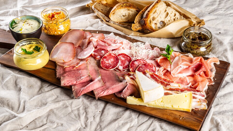 Vassoio con salumi, formaggi, salse e pane su un tavolo. | © Paul Stajan