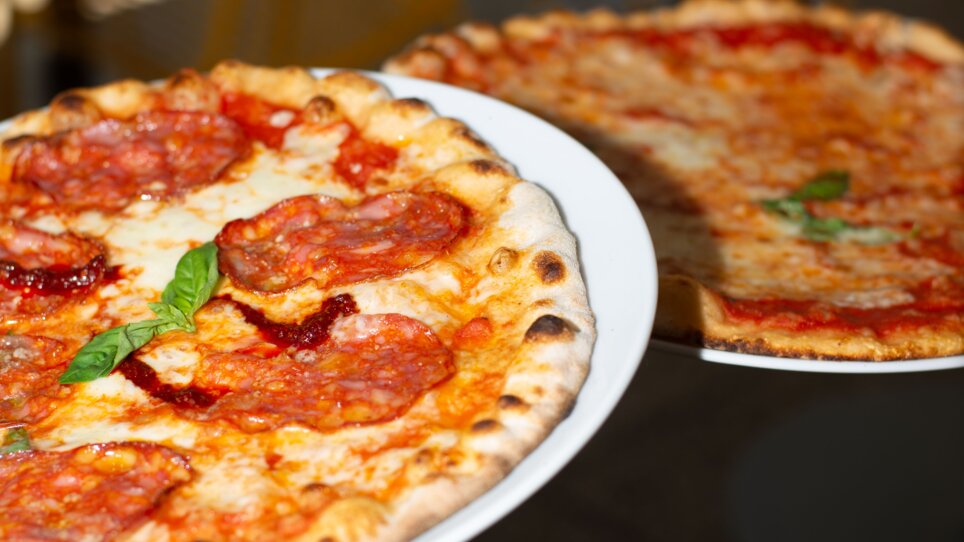 Two pizzas on a white plate, one with salami, the other with cheese. | © Florian Weitzer Hotels & Restaurants