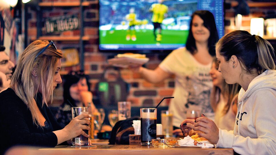 Scene sociale in un locale con cibo e bevande. | © Heinz Burgers