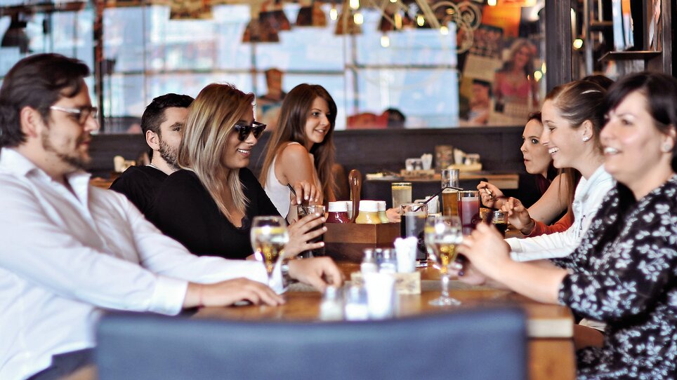 Un gruppo di amici che gode di bevande in un ristorante. | © Heinz Burgers