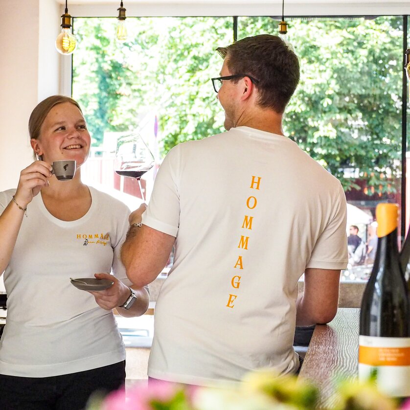 Two staff members at a café laugh and enjoy drinks in Graz. | © Hommage