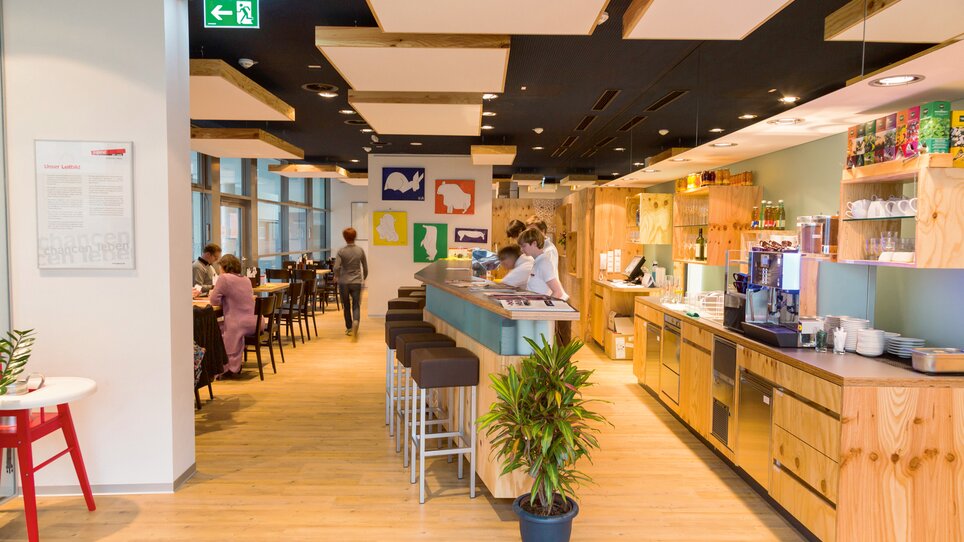 Atmosfera moderna del bistrot con dettagli in legno e opere d'arte. | © Incafe - Chris Zenz