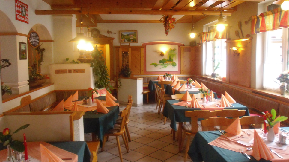 Ristorante accogliente con tavoli apparecchiati e decorazioni in legno. | © Ins Pfandl