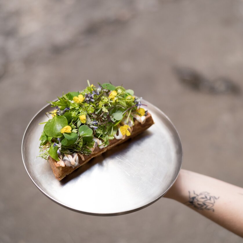 Ein grünes belegtes Brot auf einem silbernen Teller. | © Kabuff