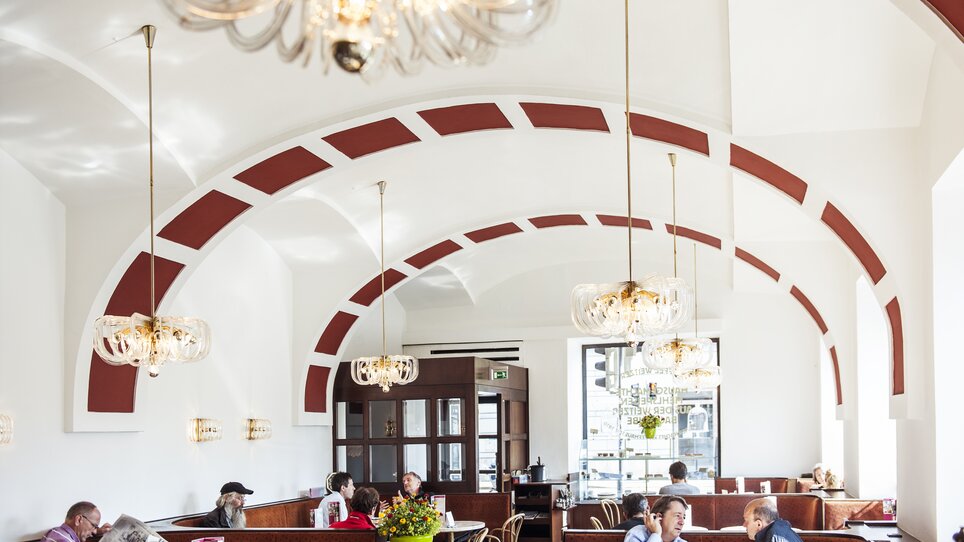 Gemütlicher Innenraum des Kaffee Weitzer mit Gästen und schönen Lampen. | © Weitzer