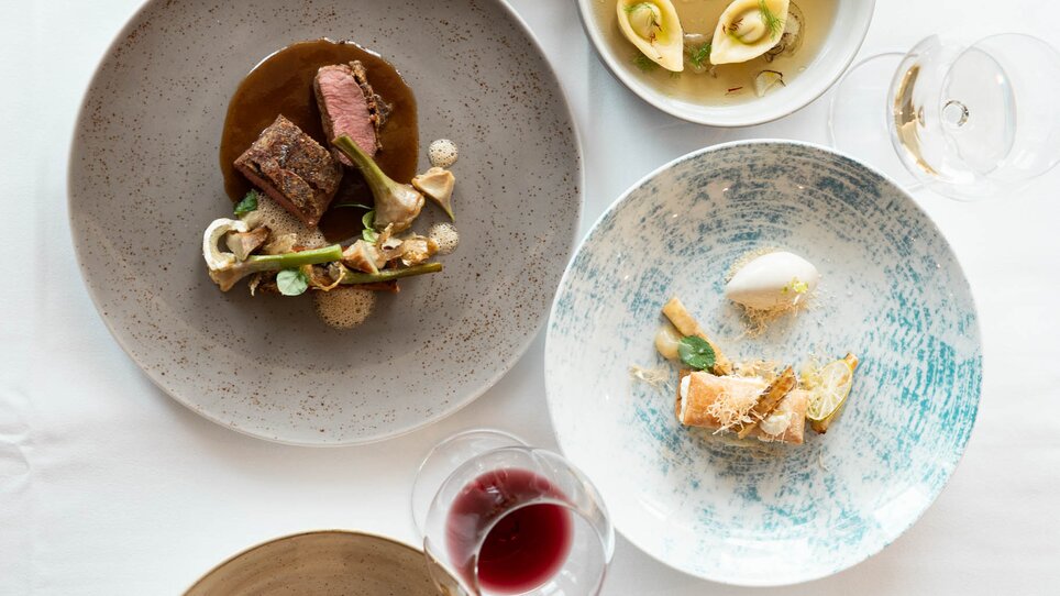 Various artistically arranged dishes on tables. | © Studio-Lou - Lukas Elsneg