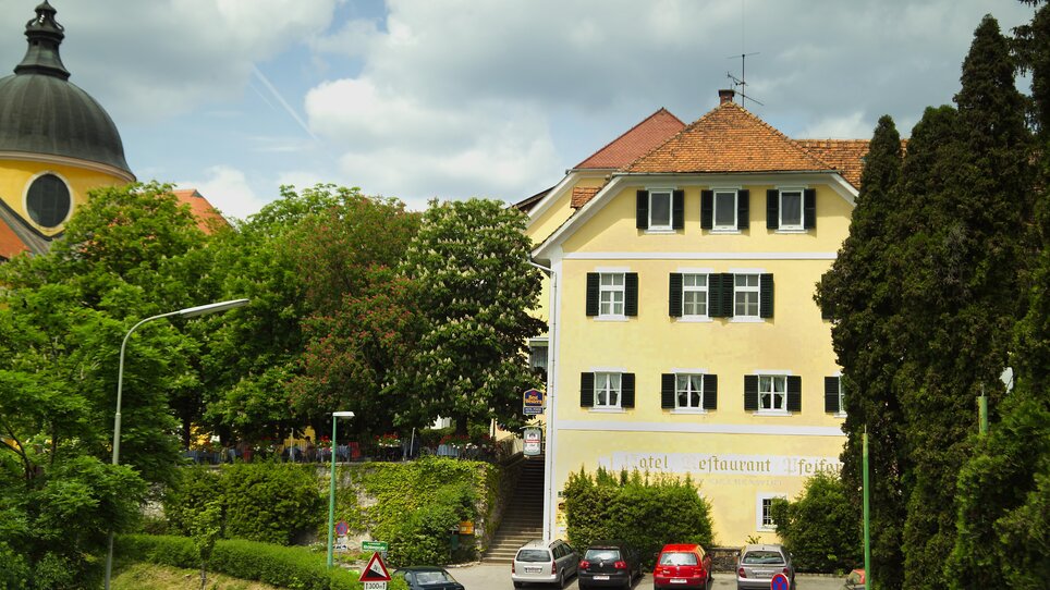 The Kirchenwirt Mariatrost building in Graz, surrounded by trees and cars. | © Kirchenwirt - Werner Krug