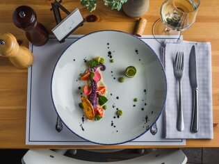 Un piatto artisticamente disposto con pesce fresco e verdure.