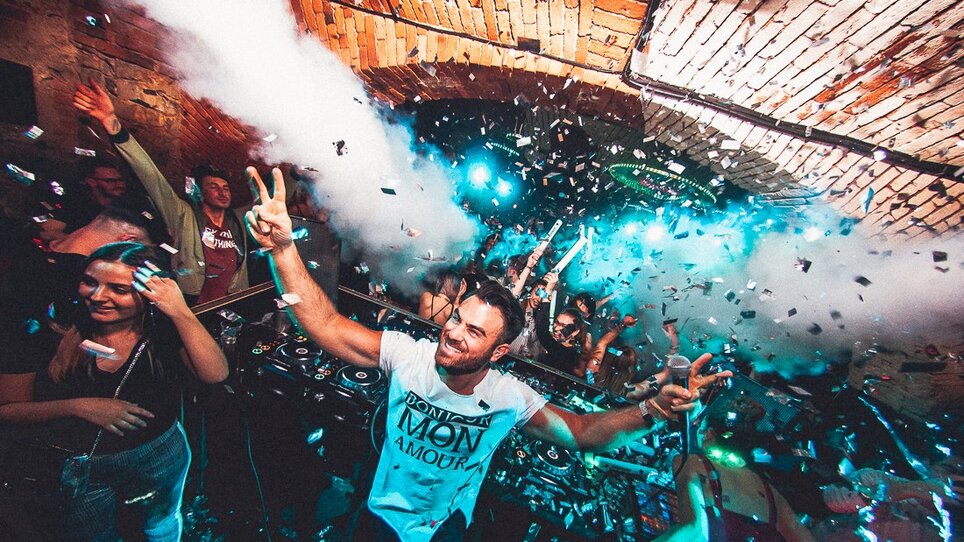 DJ performance at Kottulinsky club with partygoers and confetti.