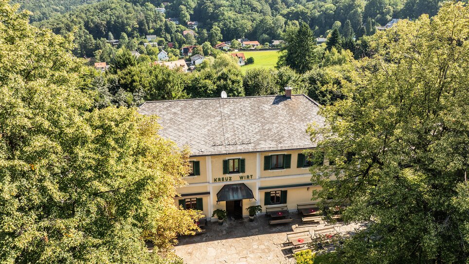 View of Kreuzwirt on Rosenberg surrounded by trees and landscape. | © kump Photography