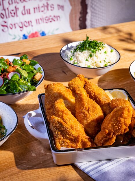Crispy chicken served with sides and fresh salads. | © Kreuzwirt am Rosenberg in Graz