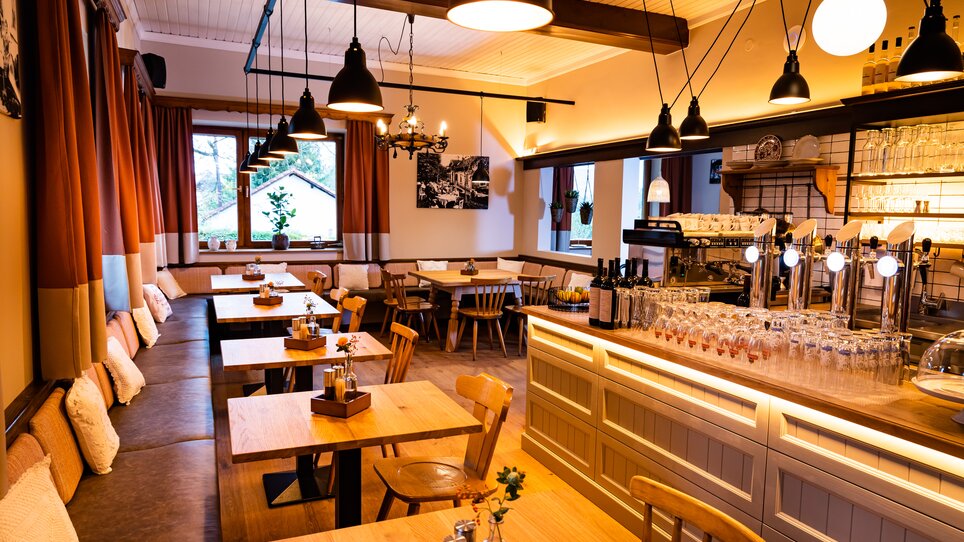 Cozy restaurant with wooden chairs and illuminated counter. | © Kreuzwirt am Rosenberg in Graz