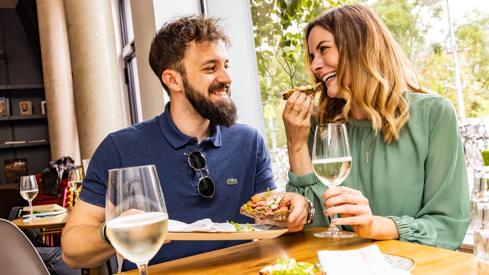 Couple enjoying food and drink at Kunsthauscafé in Graz. | © Graz Tourismus - Werner Krug