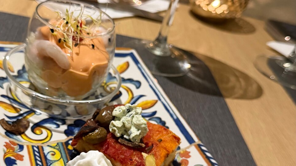 Leckeres Essen und Wein in Graz, präsentiert auf buntem Teller. | © La Corte Graz