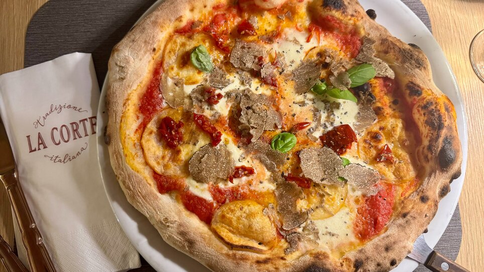 Eine Pizza mit Trüffeln, Kirschtomaten und Basilikum. | © La Corte Graz