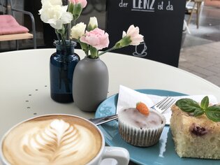 Coffee, cake, and fresh flowers at a café.