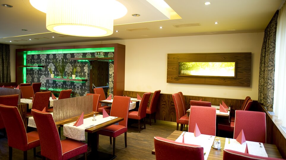 Gemütliches Restaurant mit roten Stühlen und eleganter Dekoration. | © Lindenwirt - RP photography +