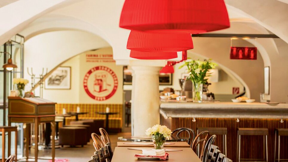 Einblick in die L'Osteria Graz mit roten Lampenschirmen und geschmackvoller Einrichtung. | © L`Osteria 