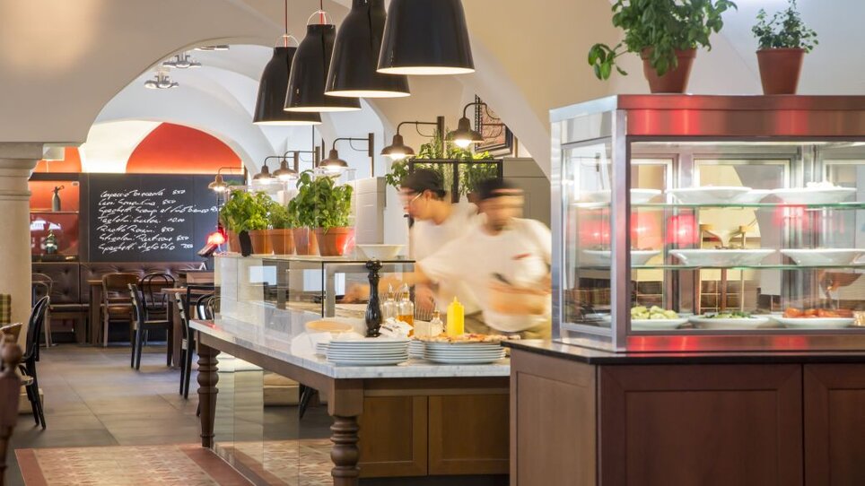 Innenansicht von L'Osteria in Graz, mit Köchen und Pflanzen. | © L`Osteria 