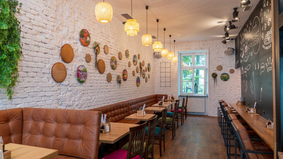 Modern restaurant interior with warm lighting accents. | © Ma Kitchen