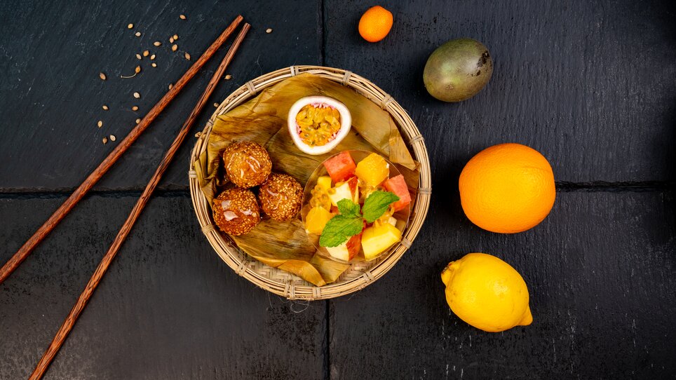 A basket with various fruits and snacks, including sweet treats. | © Ma Kitchen